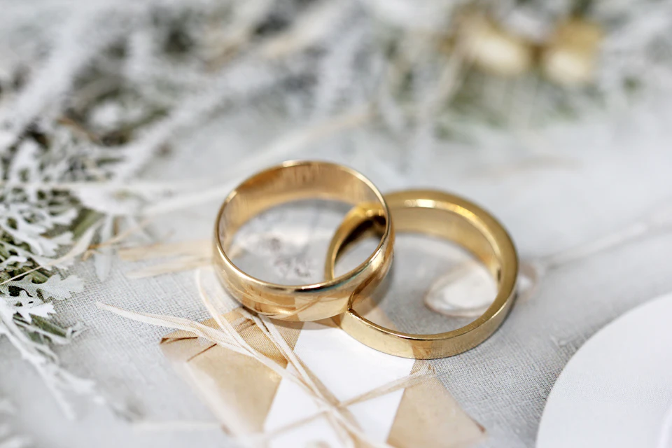 Gold wedding band on white textile
