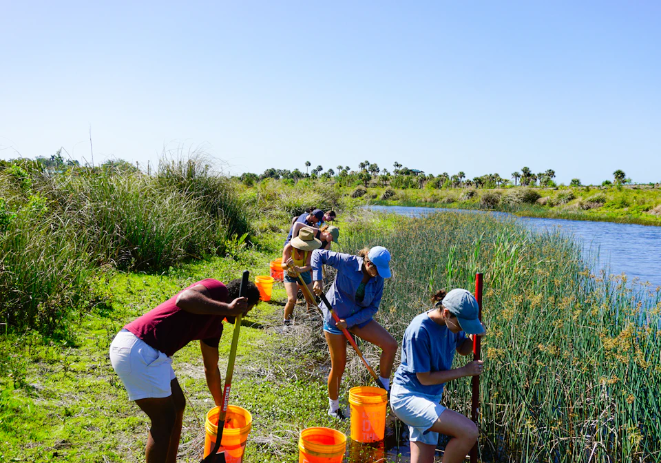 A group of people standing next to a river
