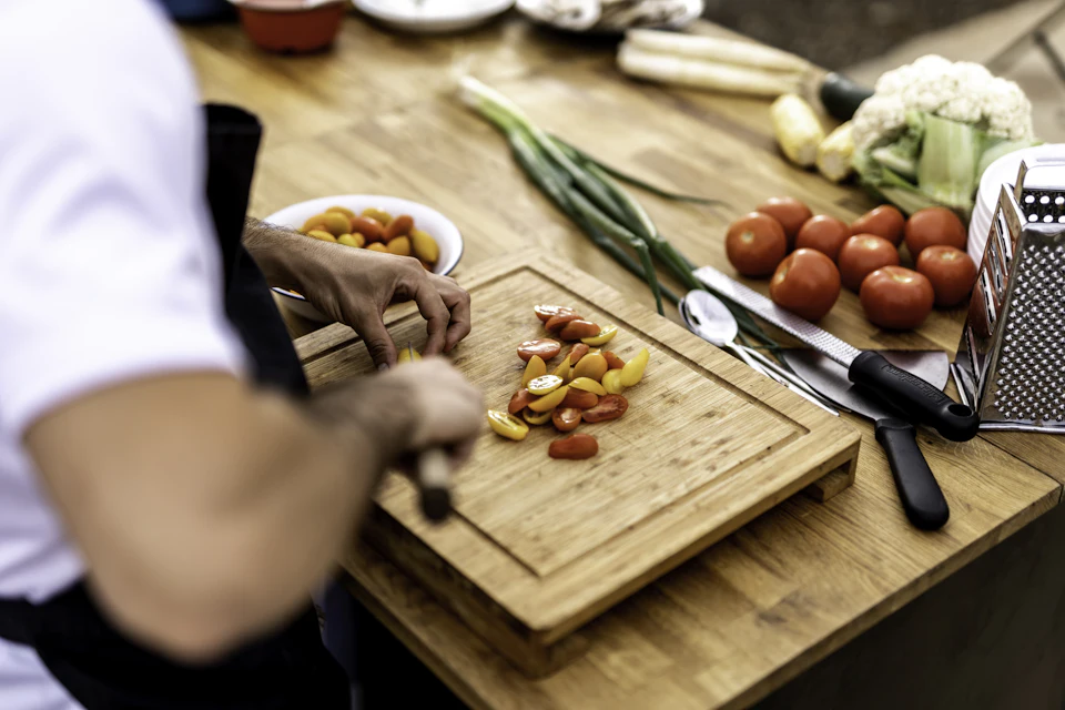 A person cutting up vegetables on a cutting board
