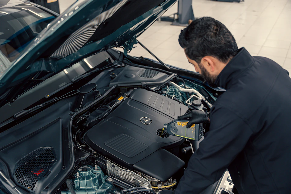 Mechanic inspecting a car engine with hood open