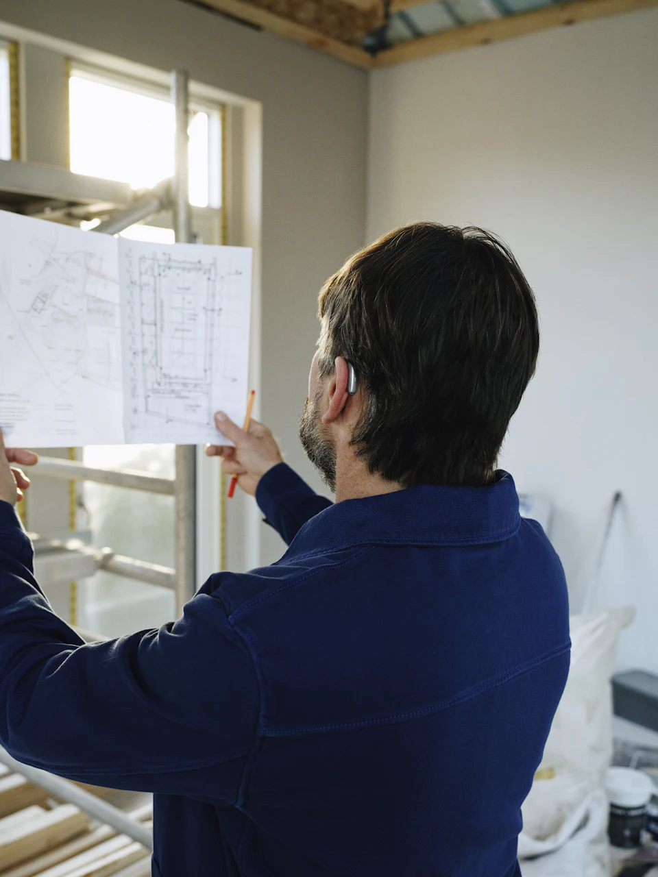 Man reviews blueprints at construction site