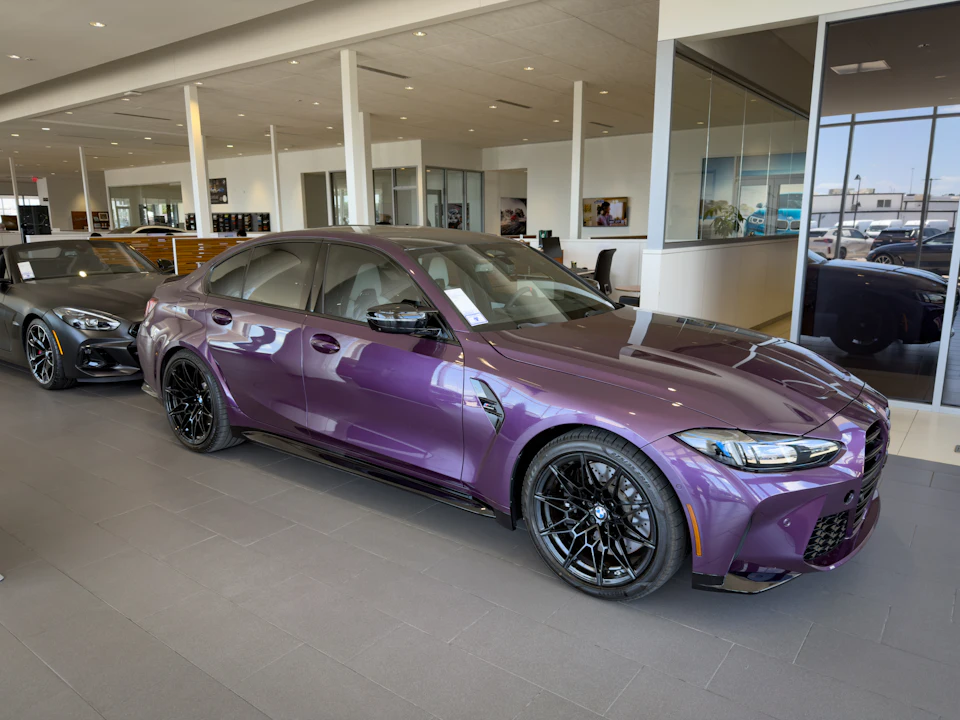 A sleek purple car displayed in a modern showroom