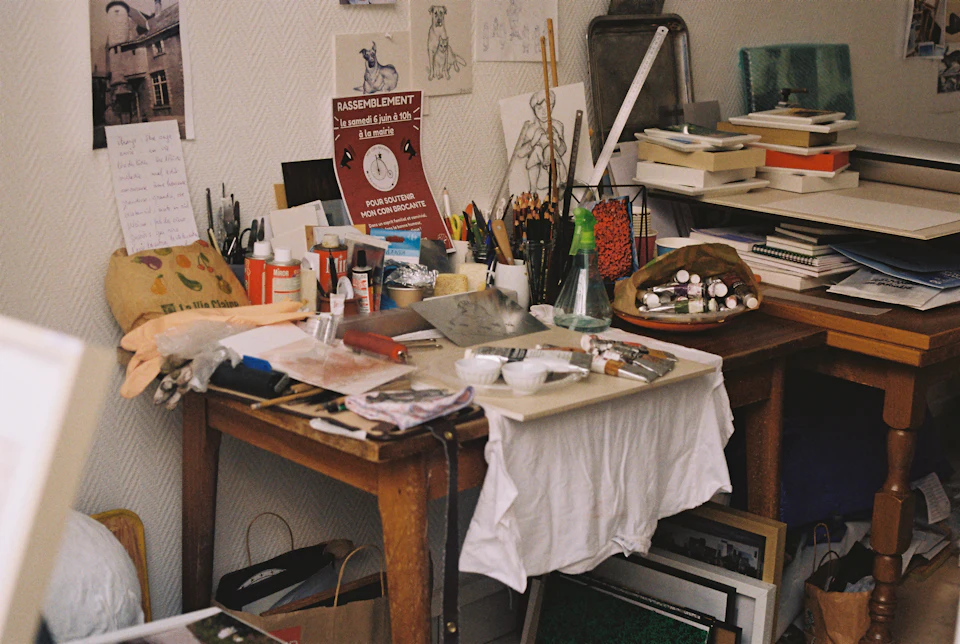 Messy artist's workspace filled with art supplies