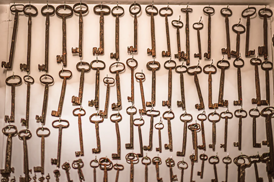 Many old rusty keys hanging on a wall