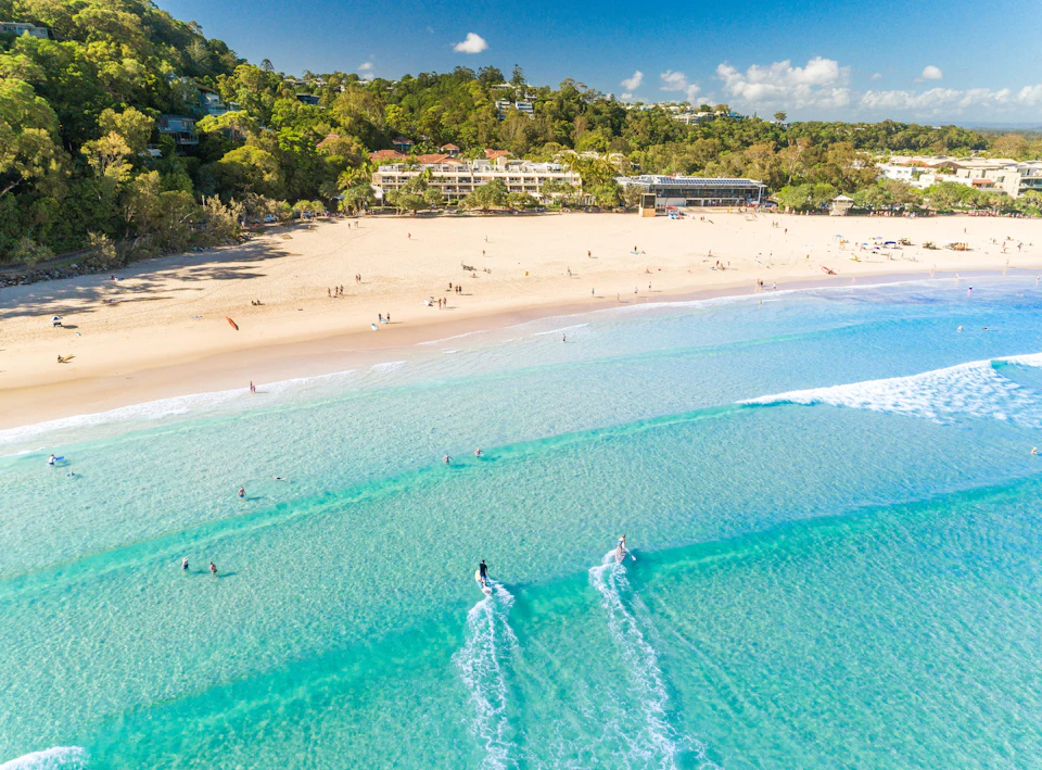 Aerial view of swimmers and paddleboarders in clear turquoise water